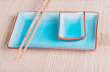 Image showing View to bamboo mat, dish and chopsticks