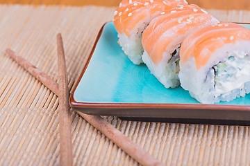 Image showing California maki sushi with fish and chopsticks