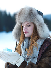 Image showing portrait of  girl with gift at winter scene and snow in backgron