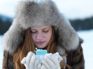 Image showing portrait of  girl with gift at winter scene and snow in backgron