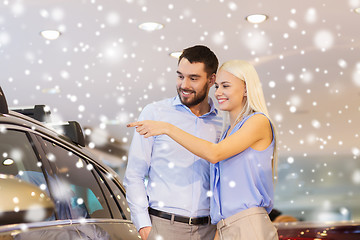 Image showing happy couple buying car in auto show or salon