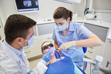 Image showing dentists treating male patient teeth at clinic