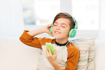 Image showing happy boy with smartphone and headphones at home