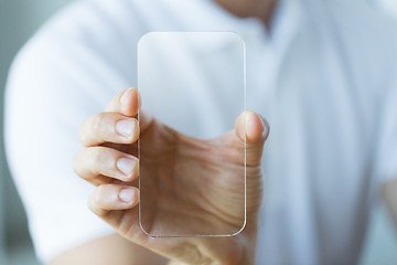 Image showing close up of male hand with transparent smartphone