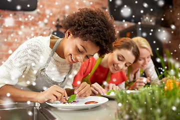 Image showing happy women cooking and decorating dishes