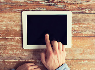 Image showing close up of male hands with tablet pc on table