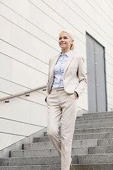 Image showing young smiling businesswoman walking down stairs