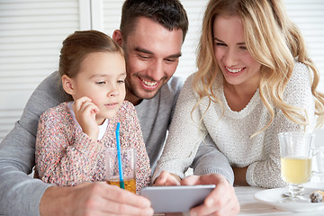 Image showing happy family with smartphone at restaurant