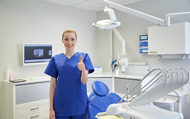 Image showing happy female dentist showing thumbs up at clinic