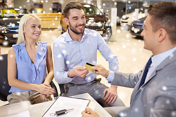 Image showing happy couple with car dealer in auto show or salon