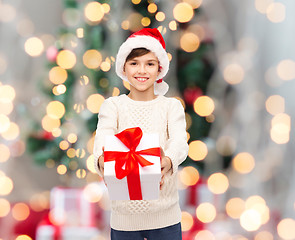 Image showing smiling happy boy in santa hat with gift box