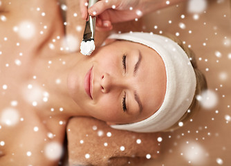 Image showing woman face and beautician applying mask in spa