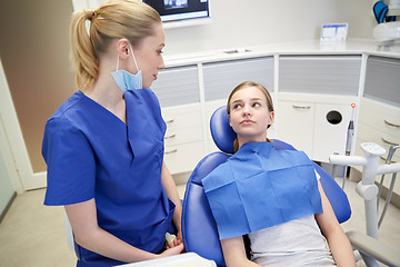 Image showing happy female dentist with patient girl at clinic