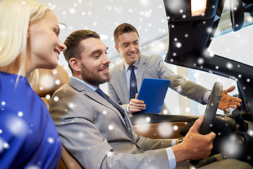 Image showing happy couple with car dealer in auto show or salon