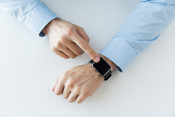 Image showing close up of male hands setting smart watch