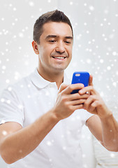 Image showing happy man with smartphone at home