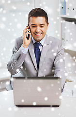 Image showing smiling businessman with laptop and smartphone