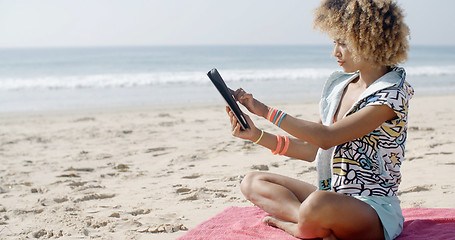 Image showing Woman Uses Touchpad Tablet On The Beach