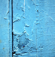 Image showing dirty stripped paint in the blue wood door and rusty nail