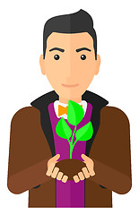 Image showing Man holding plant.