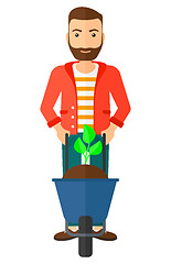 Image showing Man with plant and wheelbarrow.