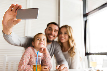 Image showing close up of family taking selfie at restaurant