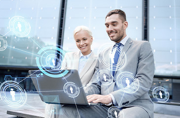 Image showing smiling businesspeople with laptop outdoors