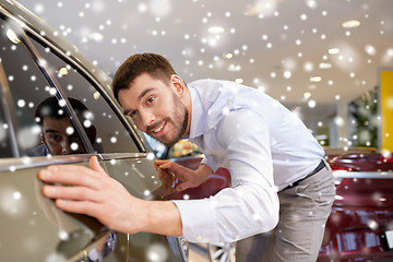 Image showing happy man touching car in auto show or salon