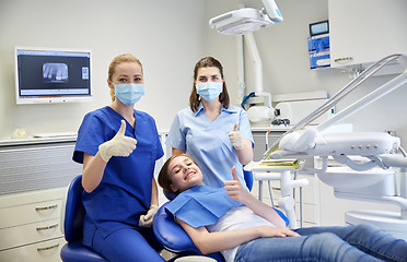 Image showing happy female dentist with patient girl at clinic