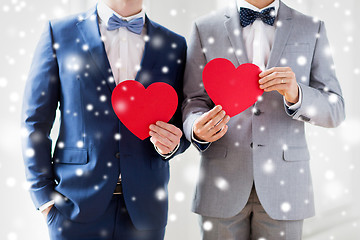 Image showing close up of male gay couple holding red hearts