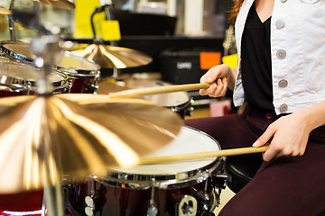 Image showing close up of woman playing cymbals at music store