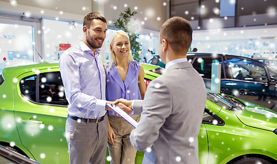 Image showing happy couple with car dealer in auto show or salon