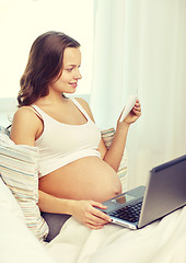 Image showing pregnant woman with laptop and ultrasound image