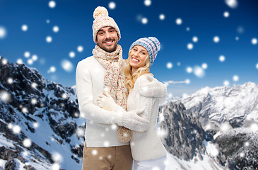 Image showing couple in winter clothes over snowy mountains