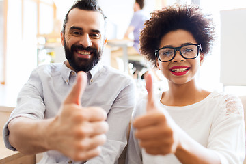 Image showing happy creative team in office showing thumbs up