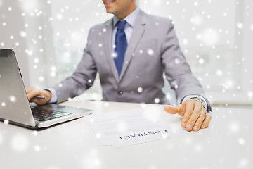 Image showing close up of businessman with laptop and papers