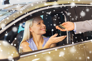 Image showing happy woman getting car key in auto show or salon