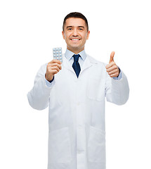 Image showing smiling male doctor in white coat with tablets