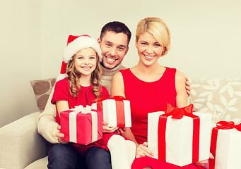 Image showing smiling family holding many gift boxes