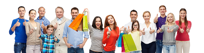 Image showing happy people with shopping bags showing thumbs up