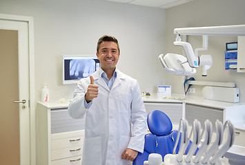 Image showing happy male dentist showing thumbs up at clinic