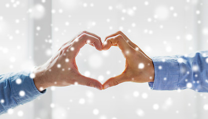 Image showing close up of male gay couple hands showing heart