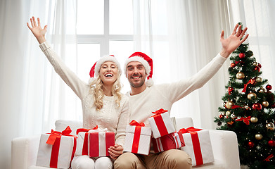 Image showing happy couple at home with christmas gift boxes