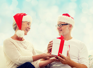 Image showing happy senior couple with gift box at home