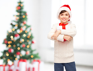 Image showing smiling happy boy in santa hat with gift box