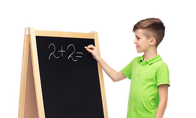 Image showing happy boy solving math on school blackboard