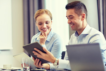 Image showing smiling business people with tablet pc in office