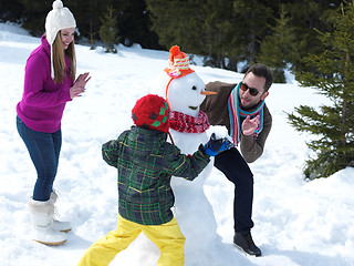 Image showing happy family making snowman