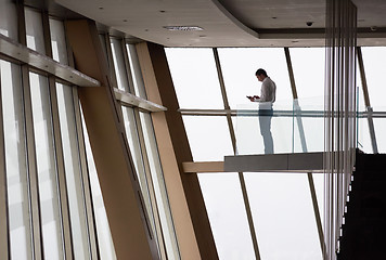 Image showing young successful business man in penthouse apartment working on 