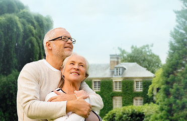 Image showing senior couple hugging over living house background